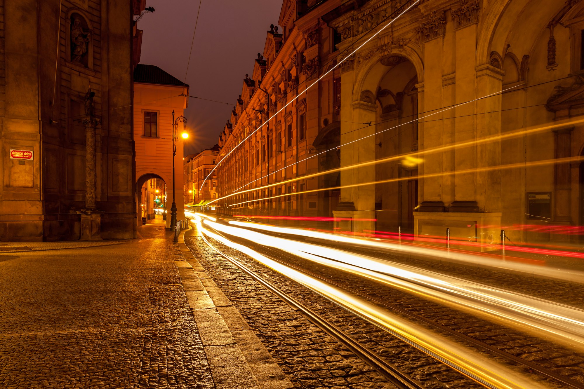 Empty street at night in Prague with car passing by, slow shutter speed